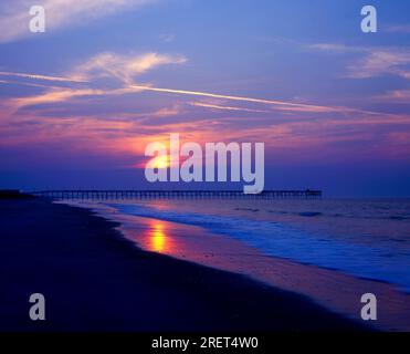 USA, North Carolina, Oak Island, Caswell Beach, Oak Island Pier, Strand bei Sonnenuntergang, niedrige Sonne spiegelt sich im Meer Stockfoto