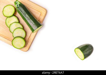 Zucchini (Cucurbita pepo), aufgeschnitten, auf Holzbrett, auf weiß, Kopierraum Stockfoto