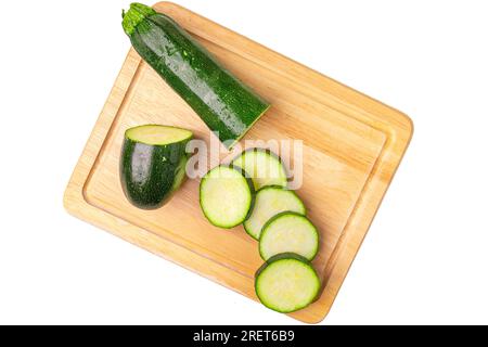 Zucchini (Cucurbita pepo), in Scheiben geschnitten, auf Holzbrett, auf Weiß Stockfoto