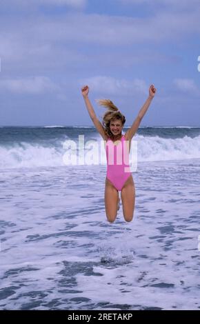 Junge Frau am Strand, Action, in die Luft springen Stockfoto