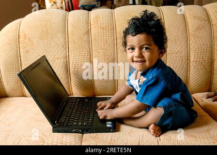 Ein südindischer 18 Monate alter Junge Ashwin, der mit dem Laptop spielt, Karnataka, Südindien, Indien, Asien Stockfoto