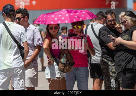 Madrid, Spanien. 29. Juli 2023. Ein paar Sonnenschirme unter einem Schirm an einem heißen Sommertag, während Sie sich anstellen, um das Finale der Könige und Königinnen im Civitas Metropolitano Stadium zu betreten. Kredit: Marcos del Mazo/Alamy Live News Stockfoto