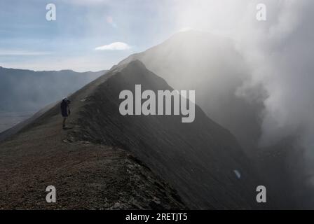 Mann, der in Rauch fotografiert, aus Mount Bromo Krater, Bromo Tengger Semeru Nationalpark, Ost-Java, Indonesien Stockfoto