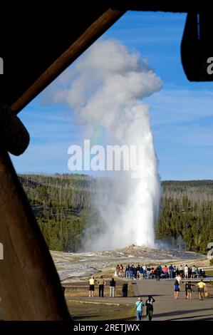 Vom Deck des Old Faithful Inn aus sehen Besucher den Ausbruch des Old Faithful Geysir im Yellowstone-Nationalpark, Wyoming, USA Stockfoto