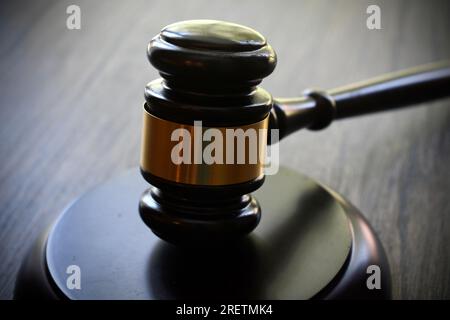 Dunkler Hammer und Block auf dunkler Holzoberfläche Stockfoto