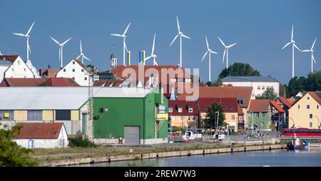 Wolgast, Deutschland. 30. Juli 2023. Windturbinen stehen bei sonnigem Wetter hinter der Stadt. Kredit: Stefan Sauer/dpa/Alamy Live News Stockfoto