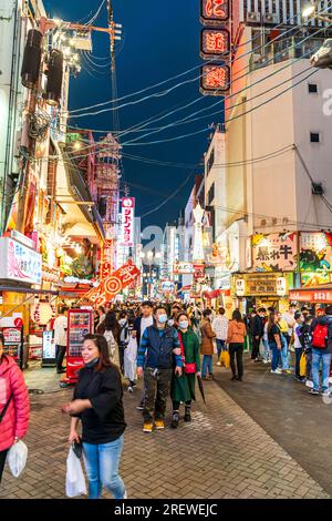 Die Touristenmassen laufen nachts durch die beliebte Dotonbori Straße in Osaka unter den hellen Lichtern und Neonschildern für die vielen Restaurants Stockfoto