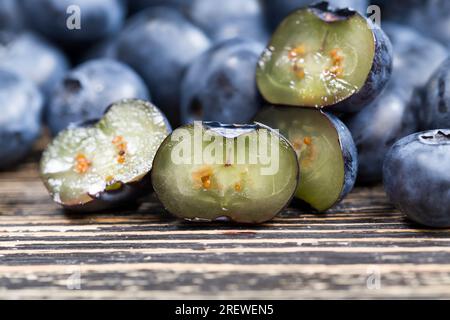 Frische, geschnittene Heidelbeeren, die roh gegessen werden können, geschnittene Heidelbeeren mit hohem Vitamingehalt, frisch geerntete und leckere Heidelbeeren in zwei Hälften geschnitten Stockfoto