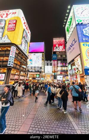 Die beliebte und überfüllte Ebisu-Brücke in Dotonbori, Osaka, mit dem Restaurant Kani Doraku und dem Eingang der Ebisu Bashi suji-Einkaufspassage. Es Ist Nacht Stockfoto