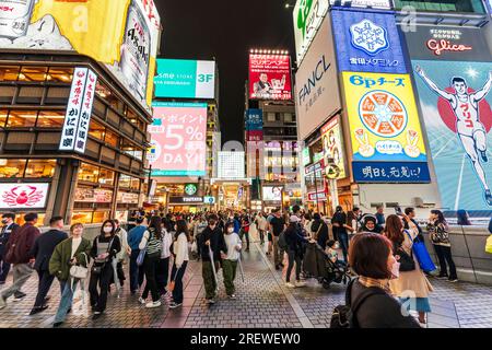 Die beliebte und überfüllte Ebisu-Brücke in Dotonbori, Osaka, mit dem Restaurant Kani Doraku und dem Eingang der Ebisu Bashi suji-Einkaufspassage. Es Ist Nacht Stockfoto