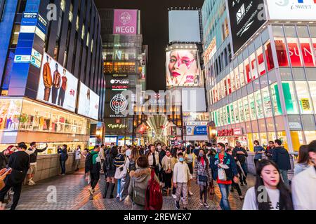 Abend auf der beliebten und überfüllten Ebisu-Brücke in Dotonbori, Osaka, mit der langen überdachten Einkaufspassage von Shin Sai Bashi Sujui an einem Ende Stockfoto