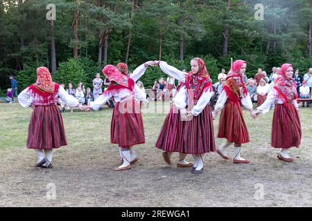 Mädchen in traditionellen estnischen Volkstrachten tanzen und feiern den estnischen Nationalfeiertag Jaanipaev auf der Insel Kihnu, Ostsee, Estland Stockfoto