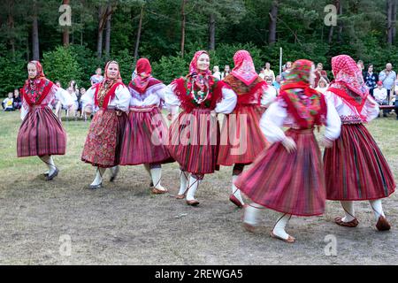 Mädchen in traditionellen estnischen Volkstrachten tanzen und feiern den estnischen Nationalfeiertag Jaanipaev auf der Insel Kihnu, Ostsee, Estland Stockfoto