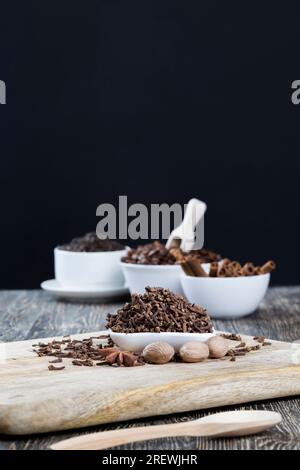 Holzlöffel und Gewürze auf dem Küchentisch, Kochen mit aromatischen Gewürzen verschiedener Art, Hausarbeit in der Küche Stockfoto