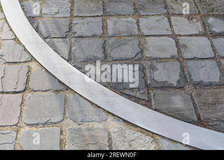 Metallbogeneinsatz in einem Steinpflaster. Splitterkreis. Andere Farbe des Steins Stockfoto