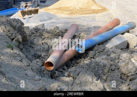 Die Kunststoffrohre mit großem Durchmesser für die Gebäudewasserkommunikation auf der Baustelle in Braun und Blau Stockfoto