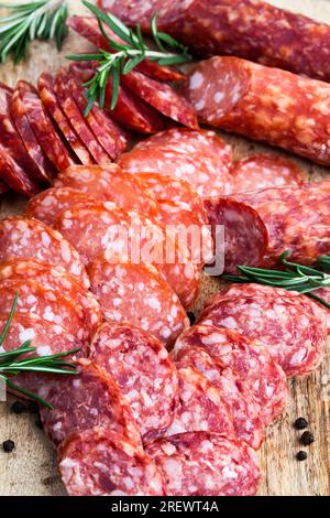 Nützliche Fleischprodukte, hergestellt in einer Fleischfabrik, Nahaufnahme von Fleischscheiben mit grünen frischen Gewürzen Stockfoto