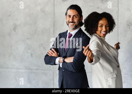 Lustiges positives, multiethnisches Business-Team, das sich über Marmorwänden posiert Stockfoto