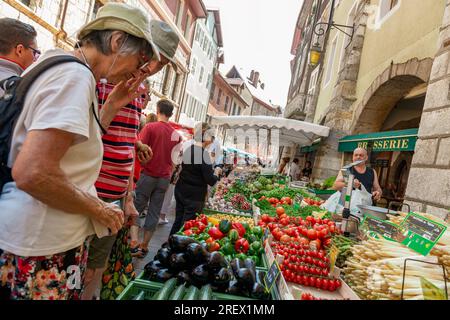 2014-06-22 Annecy, Frankreich. Leute, die Obst und Gemüse der Saison auf dem lokalen Marktplatz einkaufen. Dynamisches Foto mit Neigung. Selektiver Fokus auf f Stockfoto