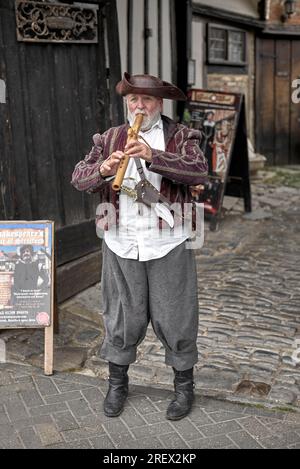 TUDOR World Flöte Player in traditionellem Kostüm begrüßt Gäste im Shrieves House, Sheep Street, Stratford upon Avon, England, Großbritannien, Stockfoto