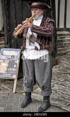 TUDOR World Flöte Player in traditionellem Kostüm begrüßt Gäste im Shrieves House, Sheep Street, Stratford upon Avon, England, Großbritannien, Stockfoto