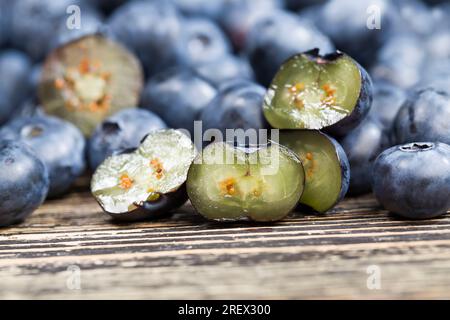 Frische, geschnittene Heidelbeeren, die roh gegessen werden können, geschnittene Heidelbeeren mit hohem Vitamingehalt, frisch geerntete und leckere Heidelbeeren in zwei Hälften geschnitten Stockfoto