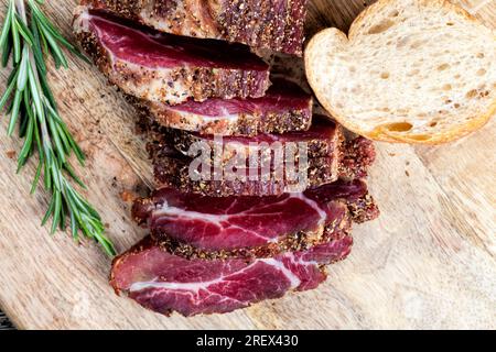 Fleisch zubereitetes mariniertes Rindfleisch, Schweinefleischprodukte mit Schmalz, auf dem Tisch mit Rosmarin geschnitten Stockfoto