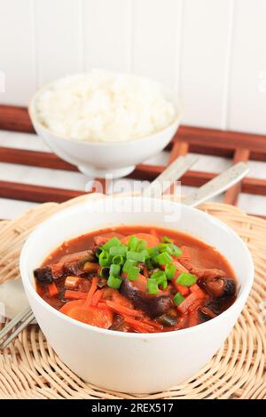 Kimchi-Suppe in White Bowl serviert mit Reis, koreanische traditionelle Kimchi Jjigae Stockfoto