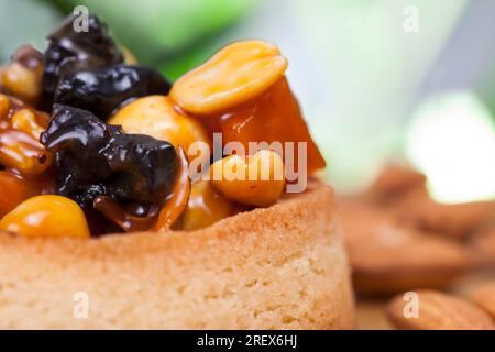 Knusprige Törtchen mit Haselnüssen, Erdnüssen und anderen Zutaten, Weizentörtchen mit Nüssen und getrockneten Früchten in Sahne-Karamell, Weizentörtchen mit Pfeffer Stockfoto