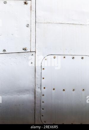 Aluminiumbleche, die durch Schweißen und Nieten miteinander verbunden werden, Nahaufnahme eines Teils der Außenhaut des Flugzeugrahmens Stockfoto