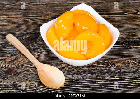 Closeup Dosen reifen Orangenpfirsiche, Obst in Zuckersirup mit Zucker konserviert, Pfirsiche sind köstlich und ohne Haut Stockfoto