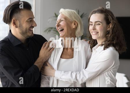 Glückliche ältere mutter und erwachsener Sohn und Tochter, die sich umarmten Stockfoto