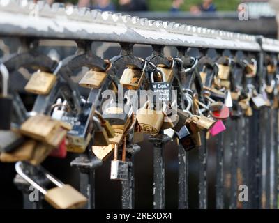 Nahaufnahme einer Reihe von Vorhängeschlössern mit sentimentalen Botschaften, die an Metallgeländern entlang des Kanals am Camden Lock in London UK angebracht sind Stockfoto