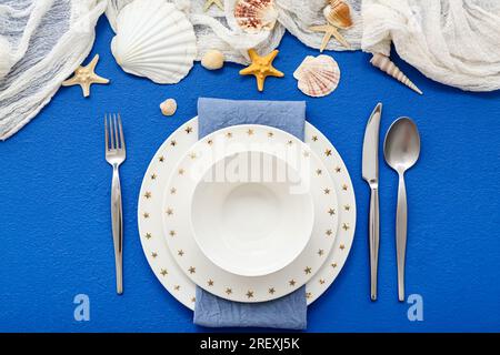 Wunderschöne Tischgestaltung mit marineblauem Dekor auf blauem Hintergrund Stockfoto