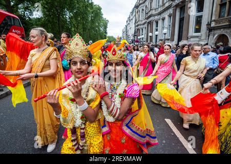 London, Großbritannien. 30. Juli 2023 Der junge Hare Krishna, der Lord Krishna und seine Gemahlin Radha während des Rathayatra Festivals oder des Festivals der Streitwagen begehrt, durchquert Piccadilly. Normalerweise werden drei dekorierte Wagen, die die Gottesformen Jagannatha, Baladeva und Subhadra tragen, vom Hyde Park zum Trafalgar Square gefahren, aber dieses Jahr ist aufgrund von Platzbeschränkungen auf dem Platz nur ein Wagen erlaubt. Sobald Sie auf dem Platz sind, genießen die Gläubigen kostenlose vegetarische Speisen und Erfrischungen während des Festivals. Kredit: Stephen Chung / Alamy Live News Stockfoto
