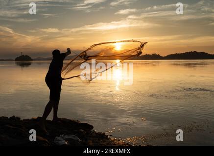 Guwahati, Indien. 30. Juli 2023 Ein Fischer, der am Sonntag, den 30. Juli 2023, bei Sonnenuntergang in Guwahati, Assam, Indien, im Fluss Brahmaputra angeln wird. Kredit: David Talukdar/Alamy Live News Stockfoto