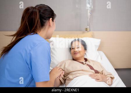 Arzt Frau ermutigen mit älteren Patienten im Krankenhaus, Arzt oder Krankenschwester kümmern sich um und Händchen halten für die trösten Senior krank, diagnostische dise Stockfoto