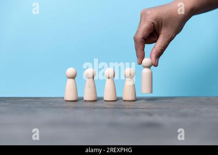 Aufbau eines starken Teams, Holzblöcke mit einem Symbol für Menschen auf blauem Hintergrund, Personalwesen und Managementkonzept. Stockfoto