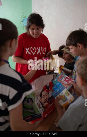 8. Juli 2023, Zaporizhzia, Ukraine: Freiwillige Polina Starodubets (33) verteilt Spielzeug an Kinder, die im Zentrum für Binnenvertriebene in Zaporizhzia untergebracht sind. Man sagt, die Ukraine habe zwei Armeen - das Militär und die Freiwilligen. Diese Fotoserie dokumentiert die gemeinsame Arbeit ukrainischer und polnischer Freiwilliger bei der Verteilung humanitärer Hilfe an die Dörfer an der Front in der Region Zaporizhien: Primorsky und Stepnohirsk. Nahrungsmittel, Reinigungsmittel, Trinkwasser und ein Stromgenerator wurden den lokalen Behörden gespendet. (Kreditbild: © Amadeusz Swierk/SOPA Images via ZUMA Press Wire) EDITO Stockfoto