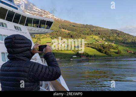 Alt, Norwegen. 2. Juni 2023. Die Leute versammeln sich bei Sonnenaufgang auf dem Hubschrauberlandeplatz des Kreuzfahrtschiffs Celebrity Silhouette, um dem Schiff beim Segeln in die Fjordstadt Olden zuzusehen. Kredit: Katie Collins/Alamy Stockfoto