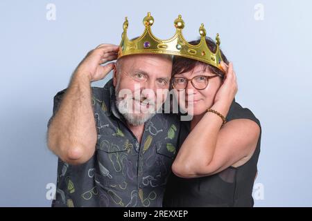 Lange Zeit eine glückliche Ehe. Ältere, verliebte Paare, die sich mit der Krone auf dem Kopf amüsieren. Glücklich zusammen. Stockfoto