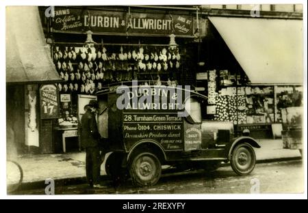 Foto von Durbin & Allwrights Lieferwagen und Fahrer vor dem Laden, der frische Produkte direkt von seinen Devonshire Farmen in Honiton und Colyton verkauft. In diesem Laden werden Hühner, Kaninchen und Butter ausgestellt. Dieser Laden war in Turnham Green Terrace, Chiswick, London, Großbritannien Es gab noch einen Laden in Ealing, London. Ungefähr 1930. Stockfoto