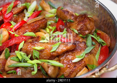 Gebratenes Fleisch mit Gemüse, grünen Zwiebeln und Pilzen, Nahaufnahme Stockfoto