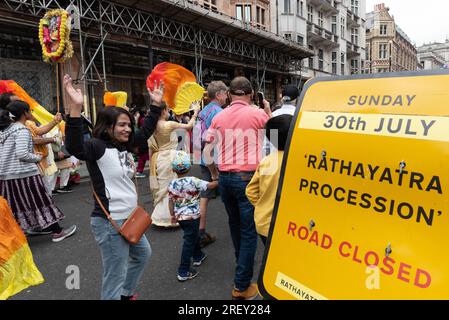 London, Großbritannien. 30. Juli 2023. Tausende Anhänger von Hare Krishna nehmen an der jährlichen Ratha Yatra-Prozession vom Hyde Park zum Trafalgar Square Teil. Bei der farbenfrohen Hindufeier sehen Sie einen Wagen mit Abbildern von Lord Jagannath und anderen Diäten, die am Seil gezogen werden, wobei Teilnehmer Musik spielen, singen, tanzen und kostenloses Essen genießen. Kredit: Ron Fassbender/Alamy Live News Stockfoto