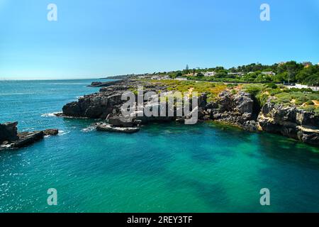 Luftaufnahme von Cascais Küstenort in Lissabon während des sonnigen Sommertags, aus Sicht der Drohne. Türkisfarbenes Wasser des Atlantiks, felsige Küste Stockfoto