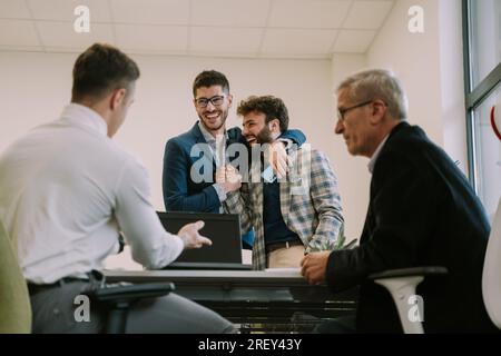 Zwei junge Geschäftskollegen stimmten zu und gaben sich einen Handschlag, um das Geschäft im Büro abzuschließen Stockfoto