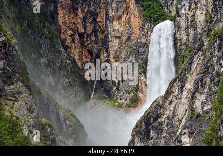 Bovec, Slowenien. 25. Juli 2023. Der Boka-Wasserfall im Triglav-Nationalpark. Fast das gesamte Gebiet des Triglav-Nationalparks befindet sich in den Julischen Alpen, der höchsten Berggruppe in Slowenien. Boka ist mit einer Gesamthöhe von 144 Metern und einer Breite von 18 Metern der Wasserfall mit dem stärksten Wasserfall in Slowenien. Kredit: Patrick Pleul/dpa/Alamy Live News Stockfoto