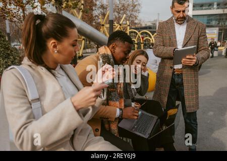 Nahaufnahme von vier Geschäftskollegen, die lachen und Spaß bei der Arbeit haben Stockfoto