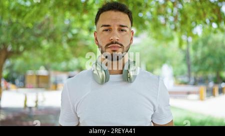Junger araber mit Kopfhörern im Park Stockfoto