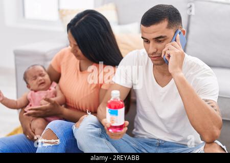 Hispanische Familie, die Telemedizin zu Hause auf dem Boden hat Stockfoto